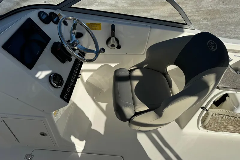 Slide: The Image of 2025 Key West 239 DFS boat interior with steering wheel and captain's chair. - 15