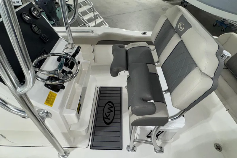 Slide: The Image of 2026 Key West 219 FS boat interior with steering console and cushioned seating. - 14
