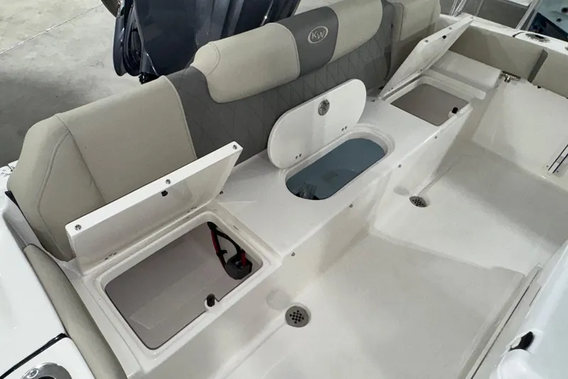 Slide: The Image of 2026 Key West 219 FS boat interior with open storage compartments and cushioned seating. - 20