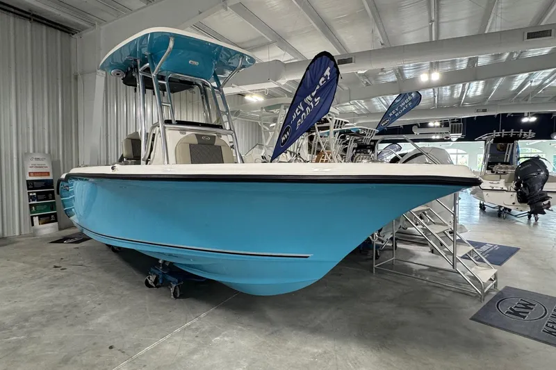 Slide: The Image of 2026 Key West 219 FS boat in showroom, featuring a sleek blue hull design. - 4