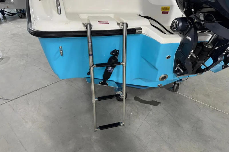 Slide: The Image of 2026 Key West 219 FS boat with blue hull and ladder on concrete floor. - 5