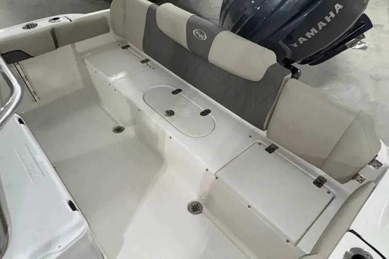 Slide: The Image of 2026 Key West 219 FS boat interior with Yamaha engine, featuring cushioned seating and storage compartments. - 19