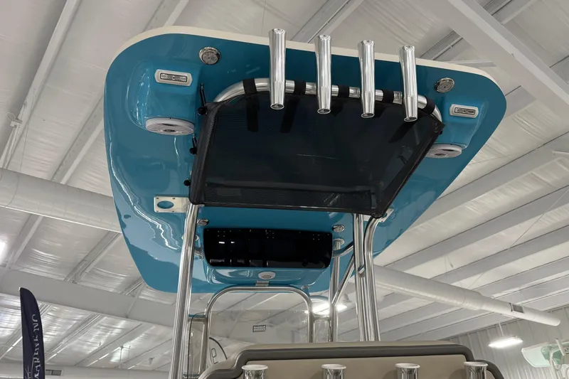 Slide: The Image of 2026 Key West 219 FS boat top view, featuring blue canopy and rod holders in a showroom. - 23