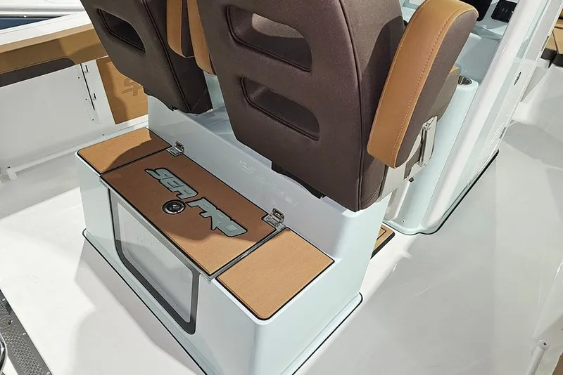 Slide: The Image of 2026 Sea Pro 245FLX Sandbar boat interior with brown seating and storage compartment. - 15