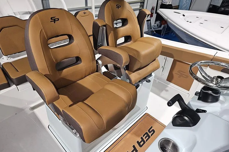 Slide: The Image of 2026 Sea Pro 245FLX Sandbar boat interior with tan seating and steering wheel. - 17