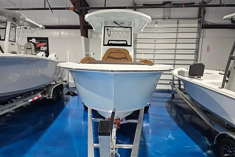 Slide: The Image of 2026 Sea Pro 245FLX Sandbar boat displayed in a showroom on a trailer. - 2