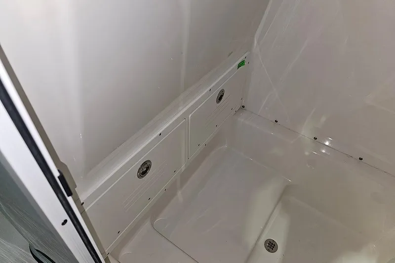 Slide: The Image of Interior view of 2026 Sea Pro 245FLX Sandbar boat, featuring sleek white surfaces and drainage system. - 26