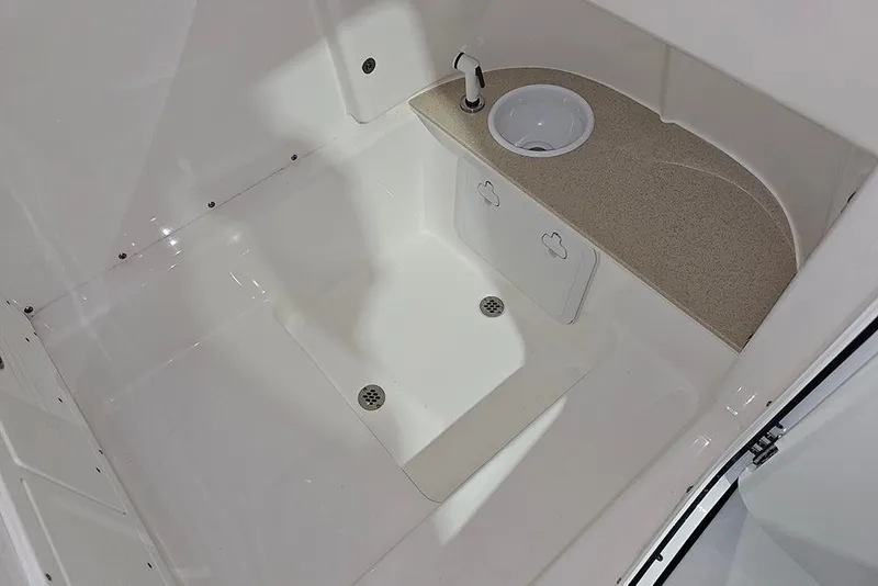 Slide: The Image of Interior of 2026 Sea Pro 245FLX Sandbar boat, featuring a compact sink and storage area. - 27