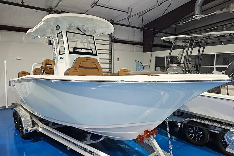 Slide: The Image of 2026 Sea Pro 245FLX Sandbar boat on trailer in showroom, featuring sleek design and modern amenities. - 3