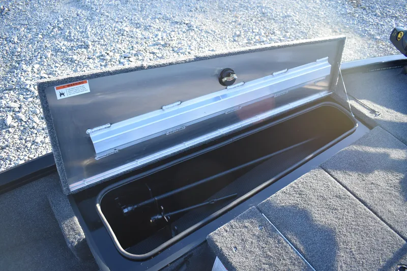 Slide: The Image of 2026 Lowe Stinger 175C boat storage compartment open on gravel surface. - 10