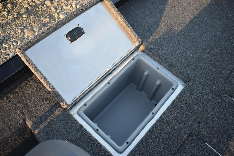Slide: The Image of Open storage compartment in 2026 Lowe Stinger 175C boat, featuring carpeted interior. - 14