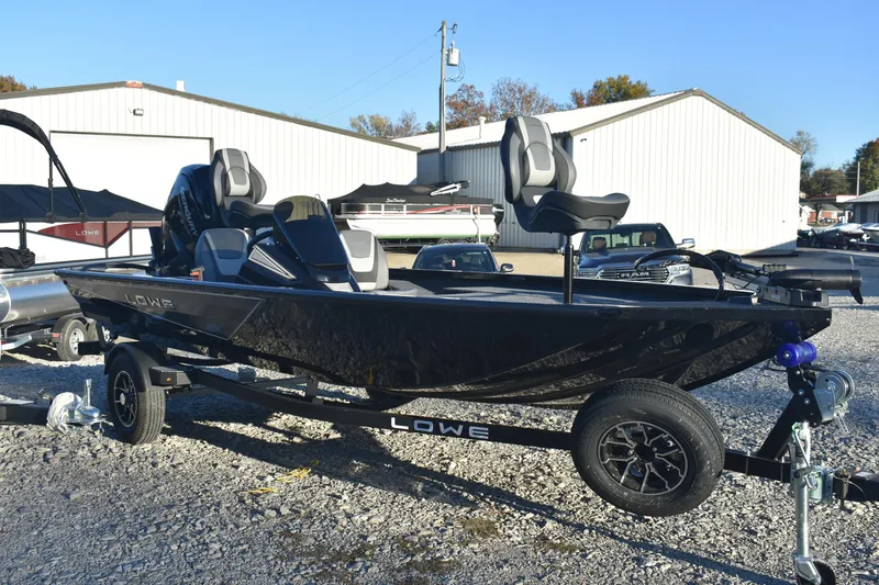 Slide: The Image of 2026 Lowe Stinger 175C fishing boat on trailer, parked outdoors. - 2