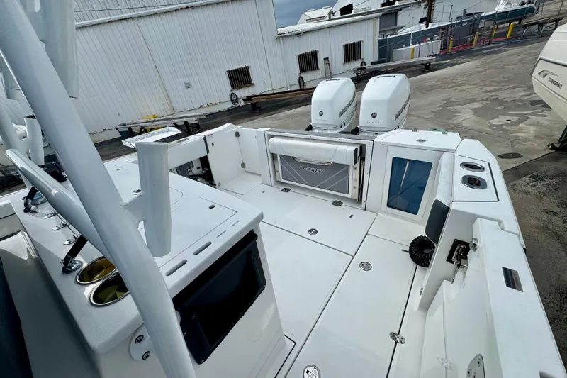 Slide: The Image of 2023 Blackfin 332 CC boat with dual engines, docked at a marina. - 102