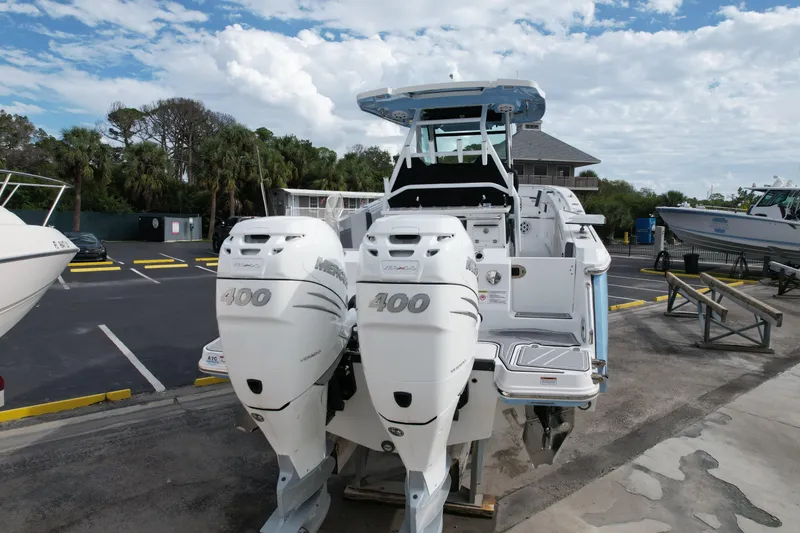 Slide: The Image of 2023 Blackfin 332 CC boat with twin 400 horsepower engines, parked outdoors. - 11