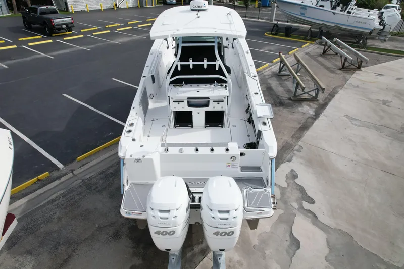 Slide: The Image of 2023 Blackfin 332 CC boat with dual 400 engines, parked in a marina. - 14