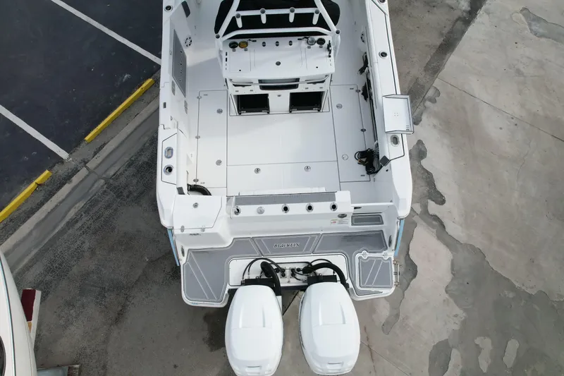 Slide: The Image of Overhead view of 2023 Blackfin 332 CC boat with dual engines in a parking area. - 16