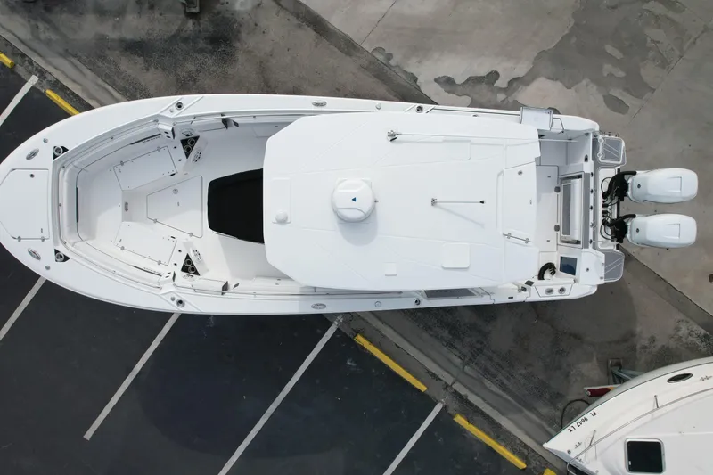 Slide: The Image of Aerial view of 2023 Blackfin 332 CC boat with dual engines, parked on concrete. - 20
