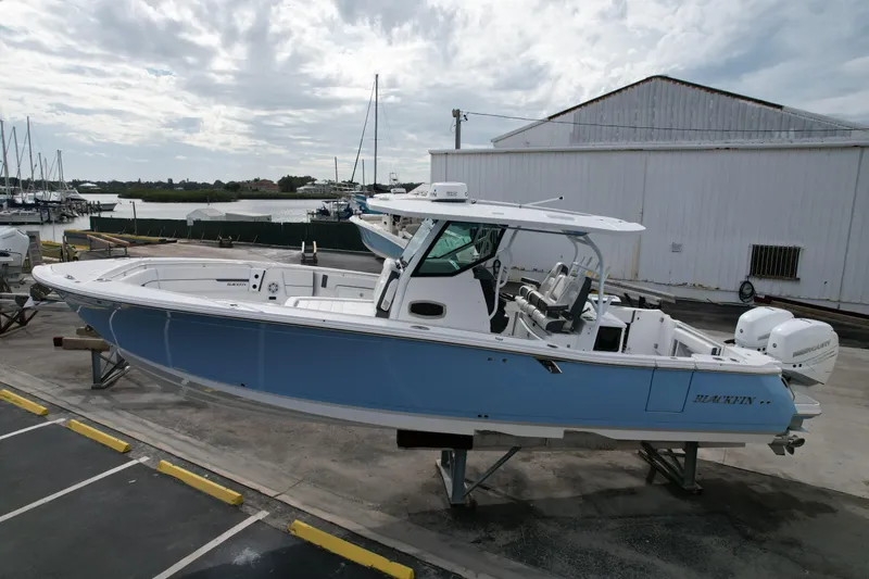 Slide: The Image of 2023 Blackfin 332 CC boat on display at a marina, side view. - 27