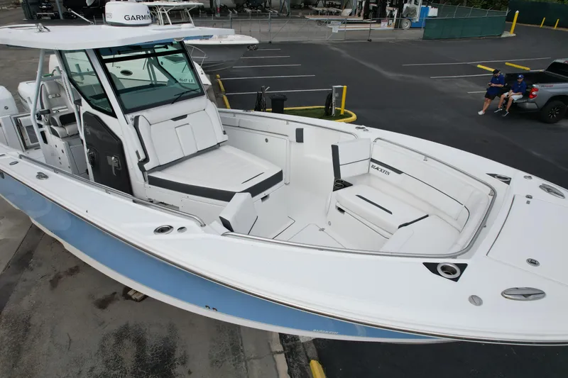 Slide: The Image of 2023 Blackfin 332 CC boat with spacious seating and modern design in a marina setting. - 36