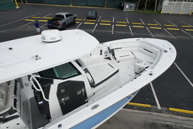 Slide: The Image of 2023 Blackfin 332 CC boat in parking lot, showcasing spacious deck and seating area. - 38