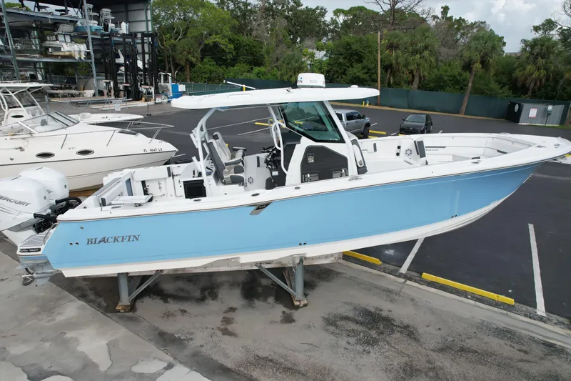 Slide: The Image of 2023 Blackfin 332 CC boat in light blue, docked at a marina. - 41