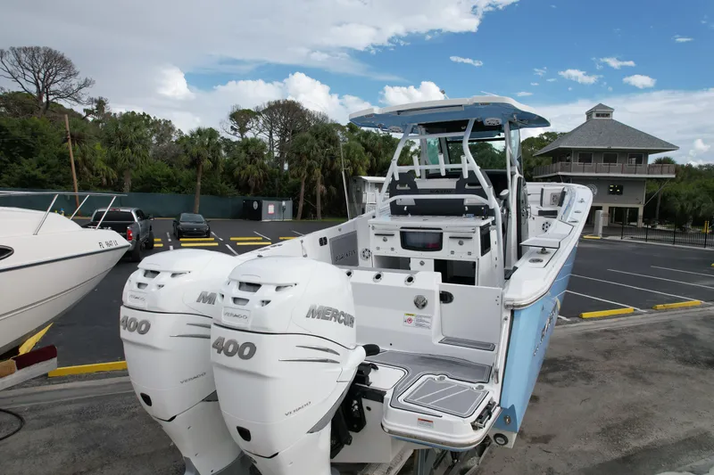 Slide: The Image of 2023 Blackfin 332 CC boat with dual Mercury 400 engines in a parking lot. - 45