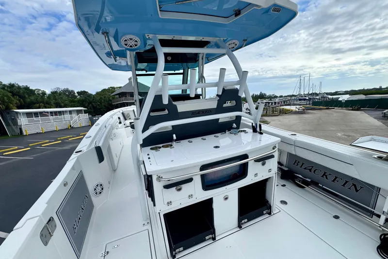 Slide: The Image of 2023 Blackfin 332 CC boat interior with fishing station and seating, docked at marina. - 62
