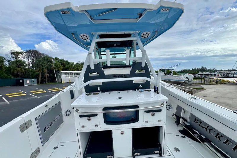 Slide: The Image of 2023 Blackfin 332 CC boat interior with seating and storage, dockside view. - 63