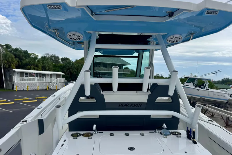 Slide: The Image of 2023 Blackfin 332 CC boat with rod holders and speakers, docked in a marina. - 66