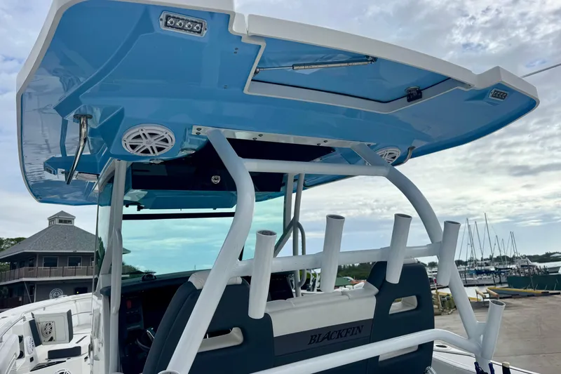 Slide: The Image of 2023 Blackfin 332 CC boat with blue hardtop and rod holders at marina. - 67