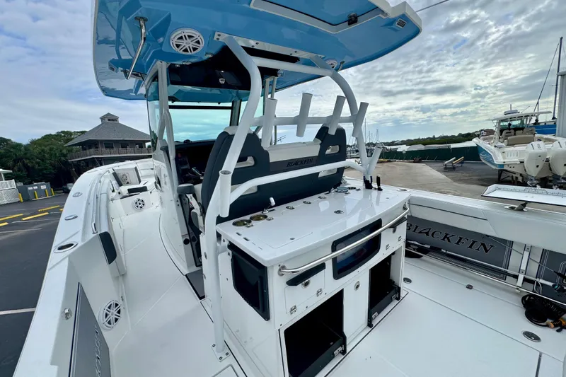 Slide: The Image of 2023 Blackfin 332 CC boat with sleek design and modern features at a marina. - 68