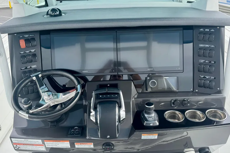 Slide: The Image of 2023 Blackfin 332 CC boat dashboard with dual Garmin screens and modern controls. - 76