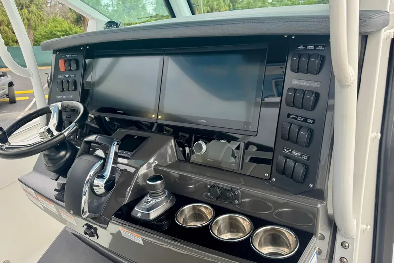 Slide: The Image of 2023 Blackfin 332 CC helm with dual screens, controls, and cup holders. - 79
