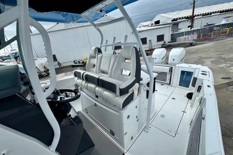 Slide: The Image of 2023 Blackfin 332 CC boat interior with seating and controls, docked at a marina. - 99