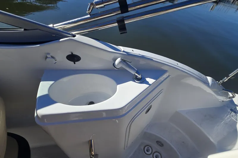 Slide: The Image of 2016 Hurricane SunDeck 2200 DC OB boat sink area with faucet and storage. - 12