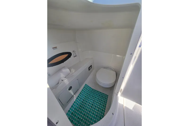 Slide: The Image of 2016 Hurricane SunDeck 2200 DC OB boat interior bathroom with toilet and storage. - 13