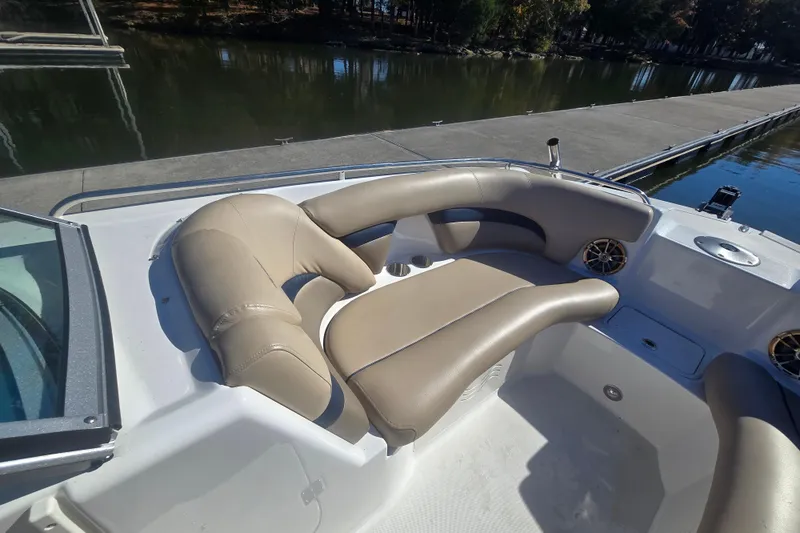 Slide: The Image of 2016 Hurricane SunDeck 2200 DC OB boat interior with beige seating near a dock. - 7