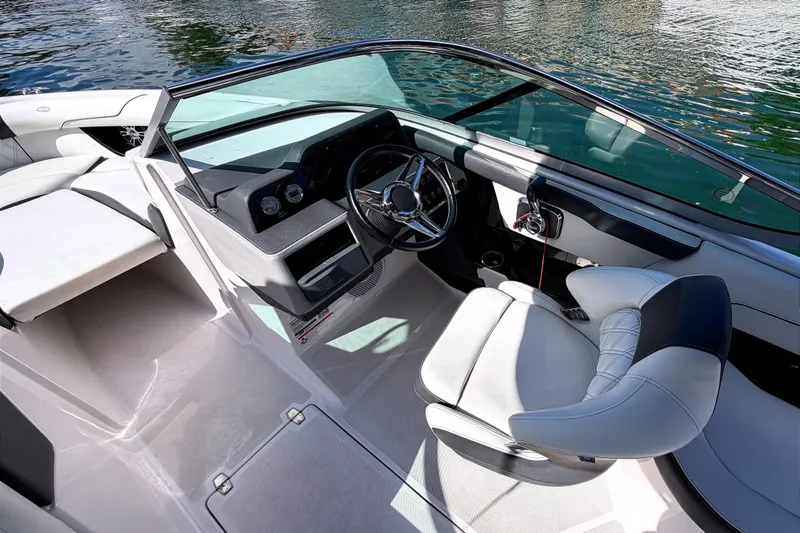 Slide: The Image of 2020 Regal 2300 Bowrider interior with steering wheel and seating, on calm water. - 14