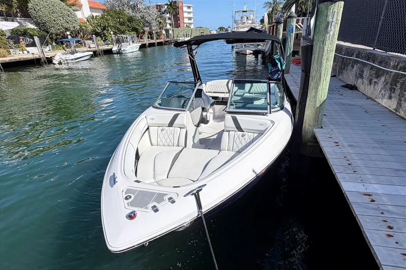 Slide: The Image of 2020 Regal 2300 Bowrider boat docked in a scenic waterfront location. - 2