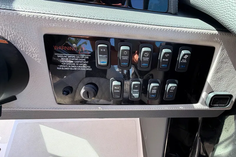 Slide: The Image of Control panel of a 2020 Regal 2300 Bowrider boat with various switches and warning label. - 21