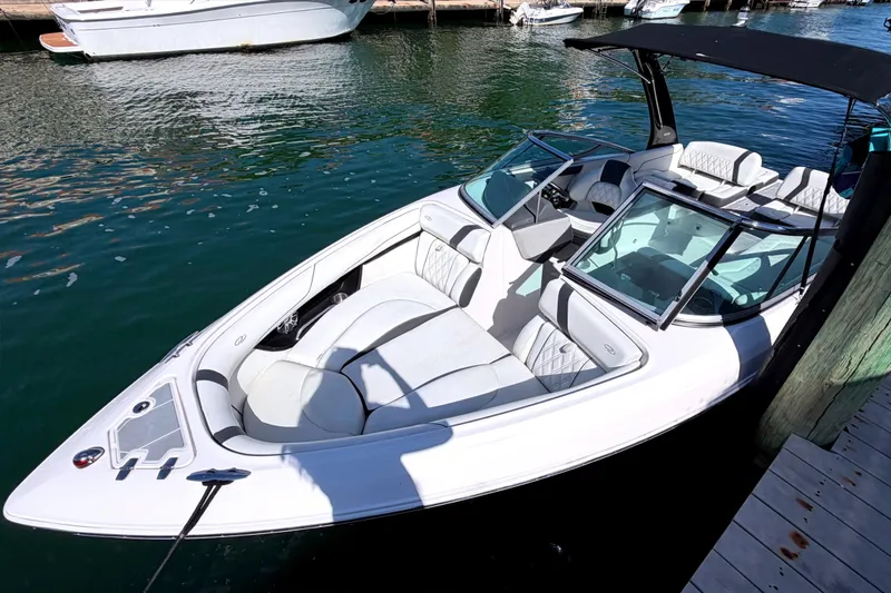 Slide: The Image of 2020 Regal 2300 Bowrider boat docked in marina, featuring sleek design and spacious seating. - 3