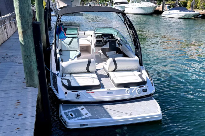 Slide: The Image of 2020 Regal 2300 Bowrider boat docked on calm water, featuring spacious seating and modern design. - 4