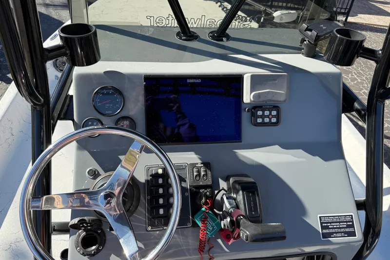 Slide: The Image of Dashboard of a 2022 Shoalwater 23 Catamaran with steering wheel and navigation controls. - 11