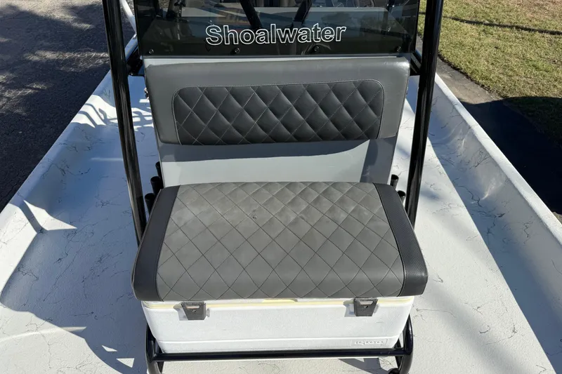 Slide: The Image of 2022 Shoalwater 23 Catamaran seat with quilted upholstery and Igloo cooler. - 23