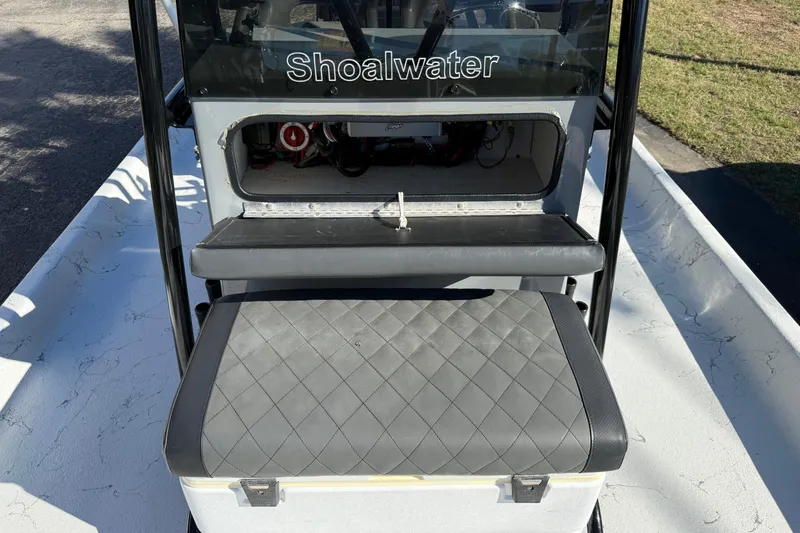 Slide: The Image of 2022 Shoalwater 23 Catamaran interior with storage compartment and cushioned seat. - 24