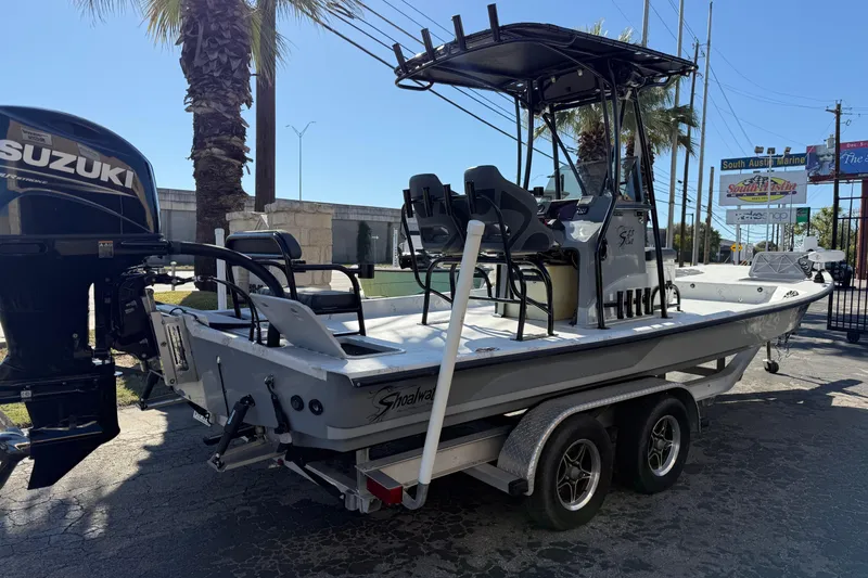 Slide: The Image of 2022 Shoalwater 23 Catamaran on trailer with Suzuki outboard motor, parked outdoors. - 3
