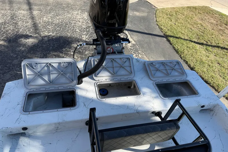 Slide: The Image of 2022 Shoalwater 23 Catamaran with open storage compartments and outboard motor. - 31