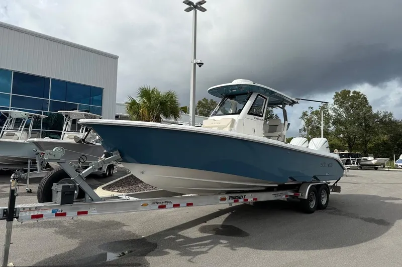 Slide: The Image of 2025 Solace 28 HCS boat on trailer at dealership, overcast sky. - 0