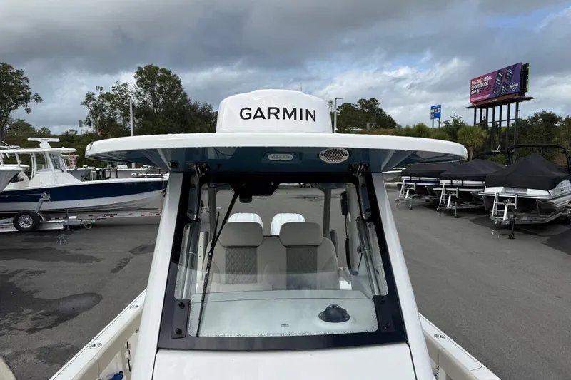 Slide: The Image of 2025 Solace 28 HCS boat with Garmin equipment, parked in a marina under cloudy skies. - 18