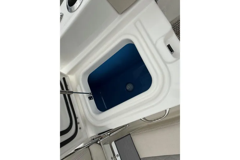 Slide: The Image of Open storage compartment on 2025 Solace 28 HCS boat, featuring a blue interior. - 8